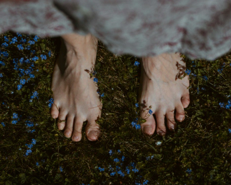 Healthy bare feet on natural grass after a barefoot run