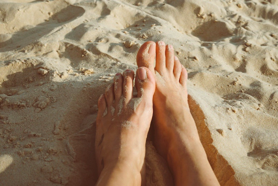 Clean bare feet on sand showing healthy natural barefoot skin