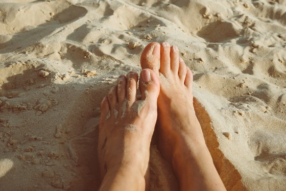 Clean bare feet on sand showing healthy natural barefoot skin