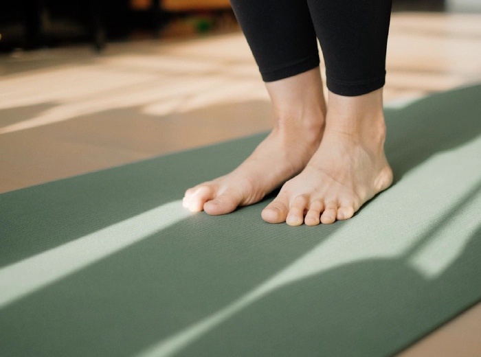 Person practicing yoga barefoot on a mat